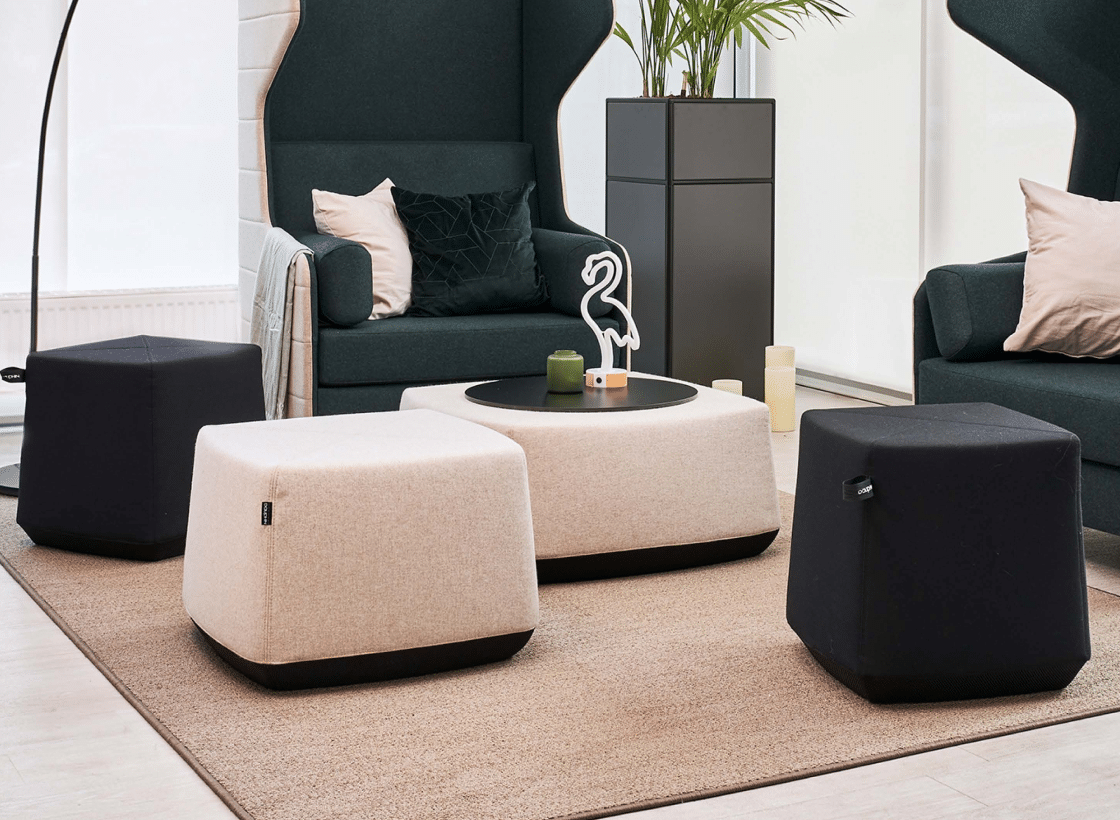 Two elegant chairs and decorative ottomans in black and cream colors, part of Dauphin's Allora Poufs collection.