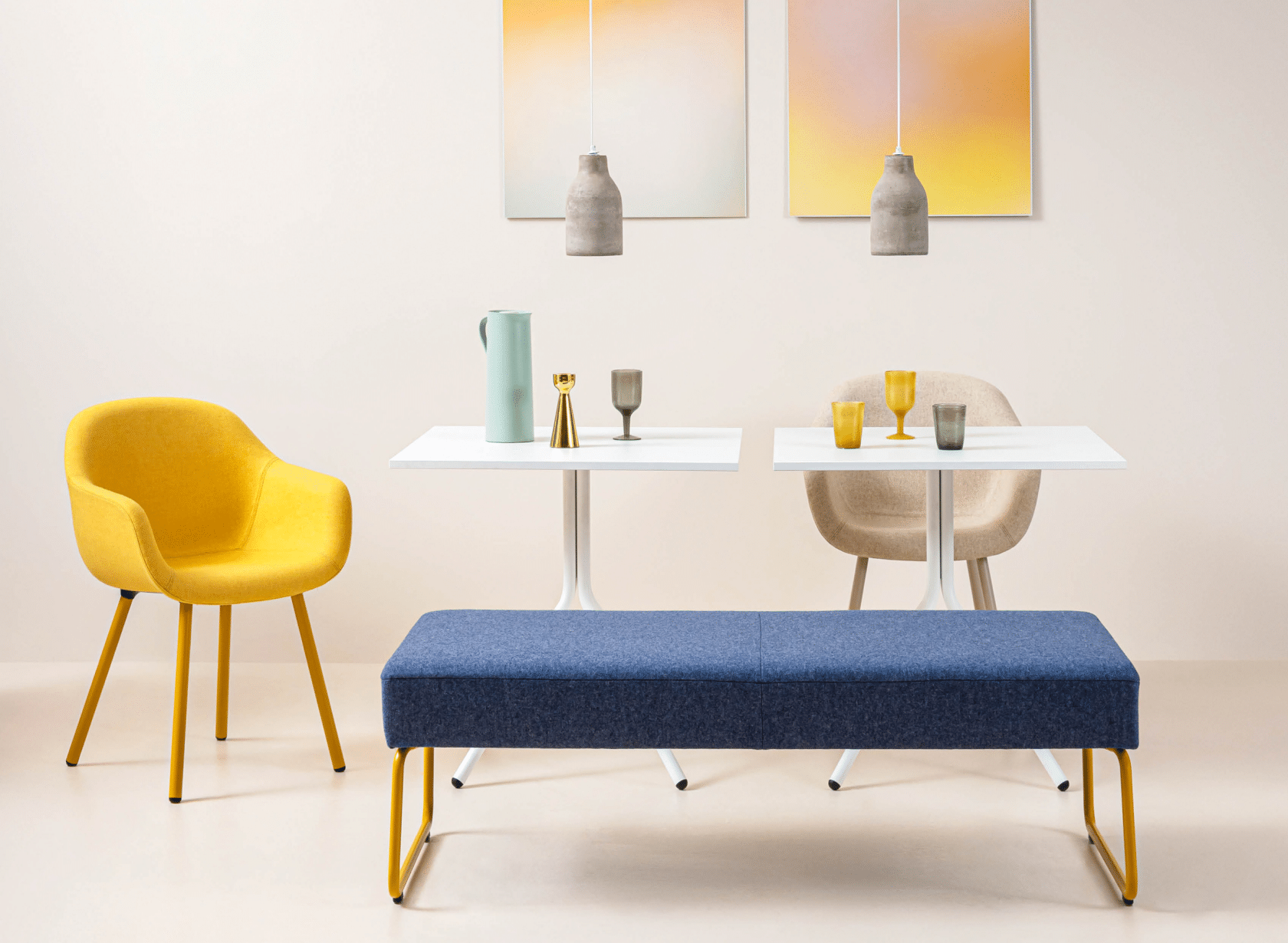 A stylish ensemble featuring a yellow chair, beige chair, and blue bench surrounding two small, white tables, from Dauphin's Fiore collection.